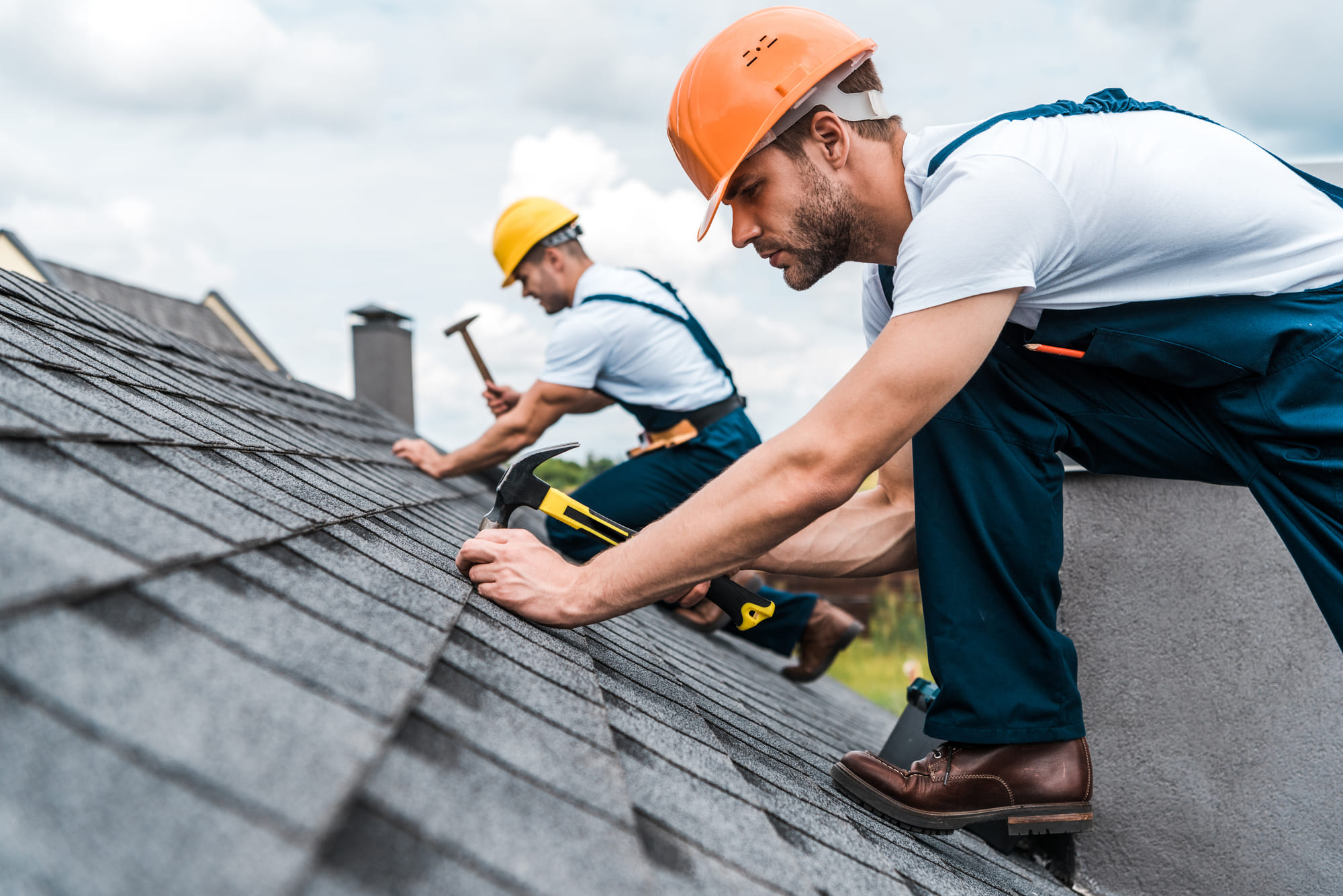 Crew members installing asphalt shingles on a home in Blue Bell, PA.
