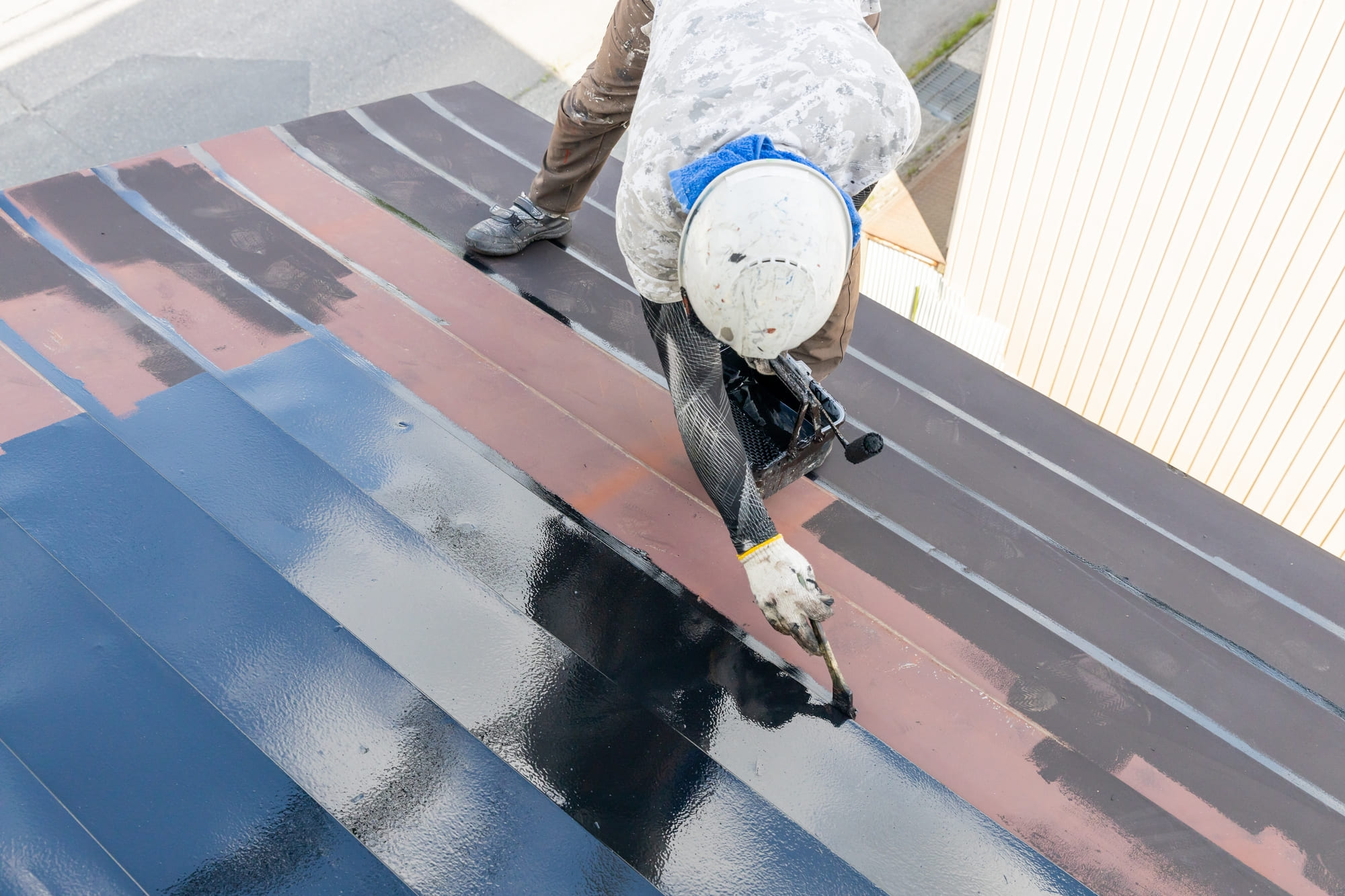 Crew member coating a roof on a home in Blue Bell, PA.